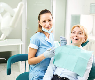  Dentist and patient girl are smiling in dentist office.