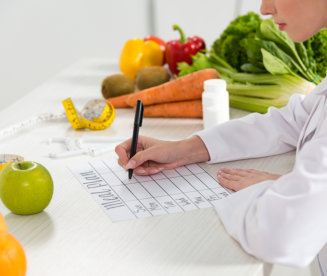 dietitian writing in meal plan at workplace