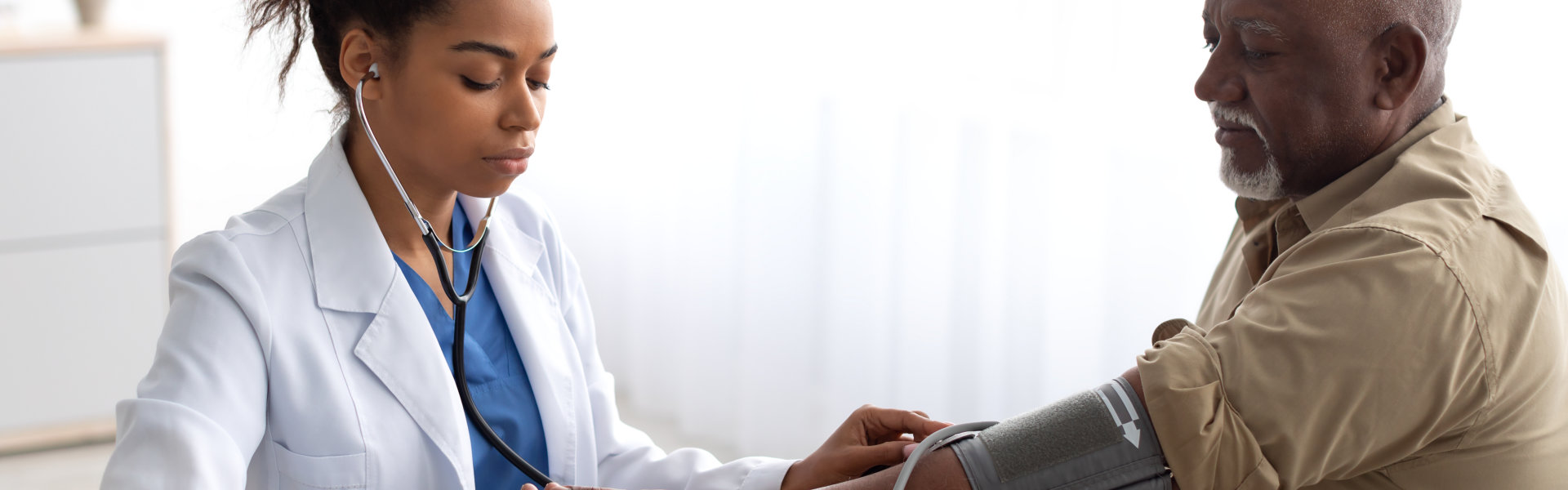 Doctor checking measuring pressure on patient's hand pulse