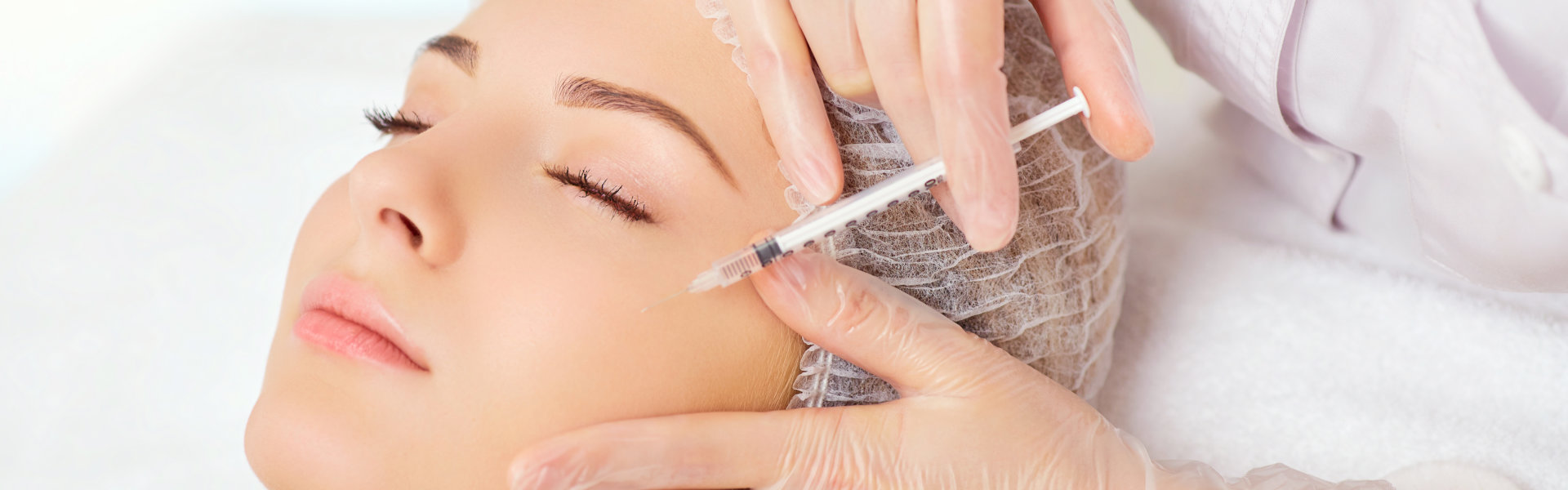 Young woman receiving cosmetic injection on her face