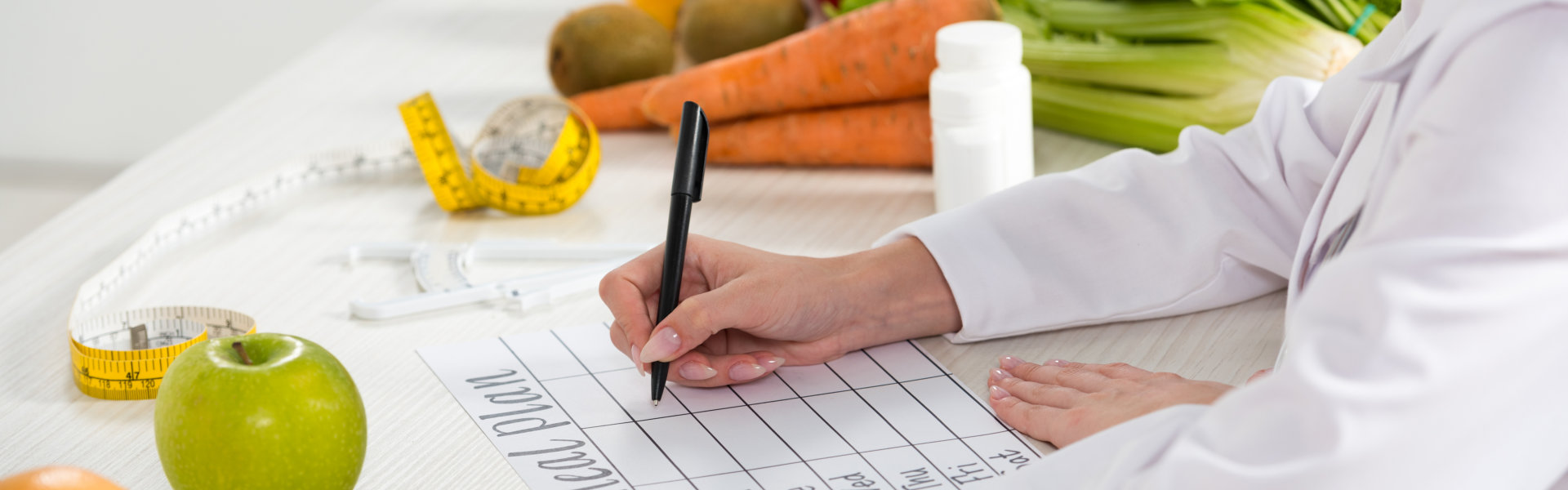 dietitian writing in meal plan at workplace