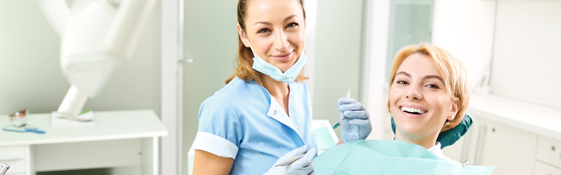 Dentist and patient girl are smiling in dentist office.